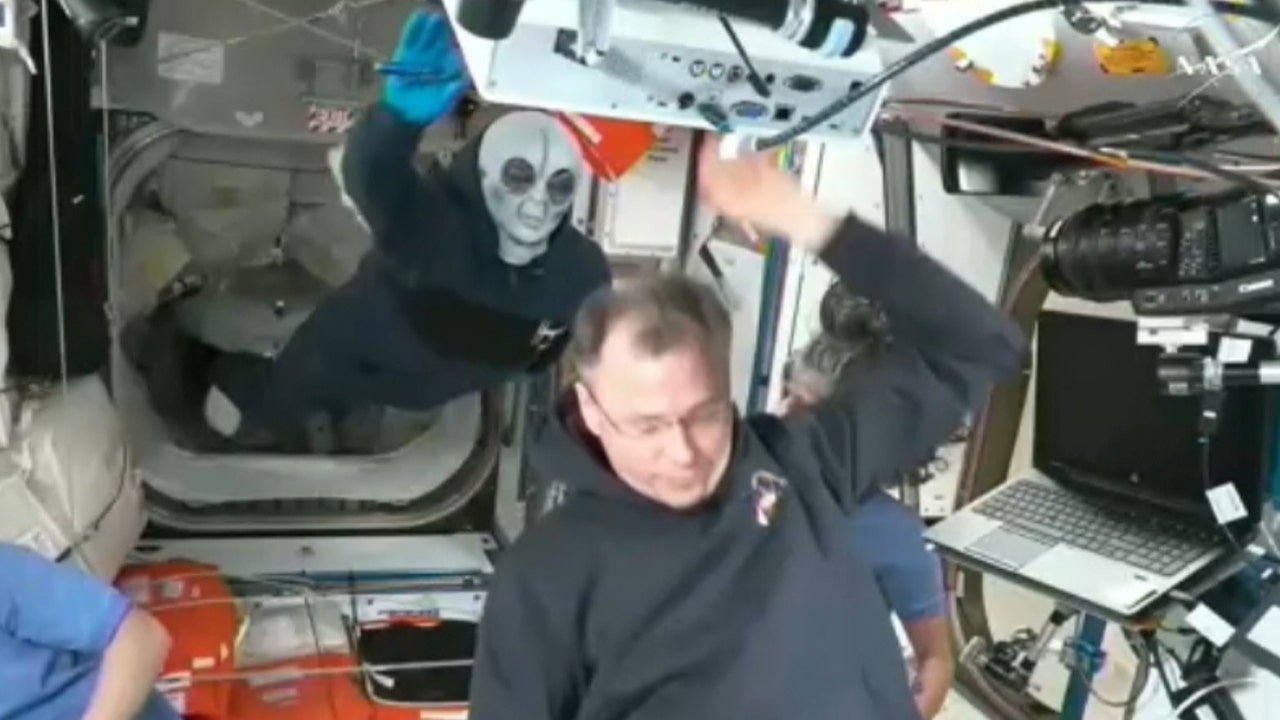 Russian cosmonaut Ivan Vagner wears alien mask while welcoming newcomers